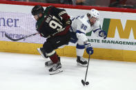 Tampa Bay Lightning right wing Nikita Kucherov (86) controls the puck as he gets hit by Arizona Coyotes left wing Taylor Hall (91) during the first period of an NHL hockey game Saturday, Feb. 22, 2020, in Glendale, Ariz. (AP Photo/Ross D. Franklin)