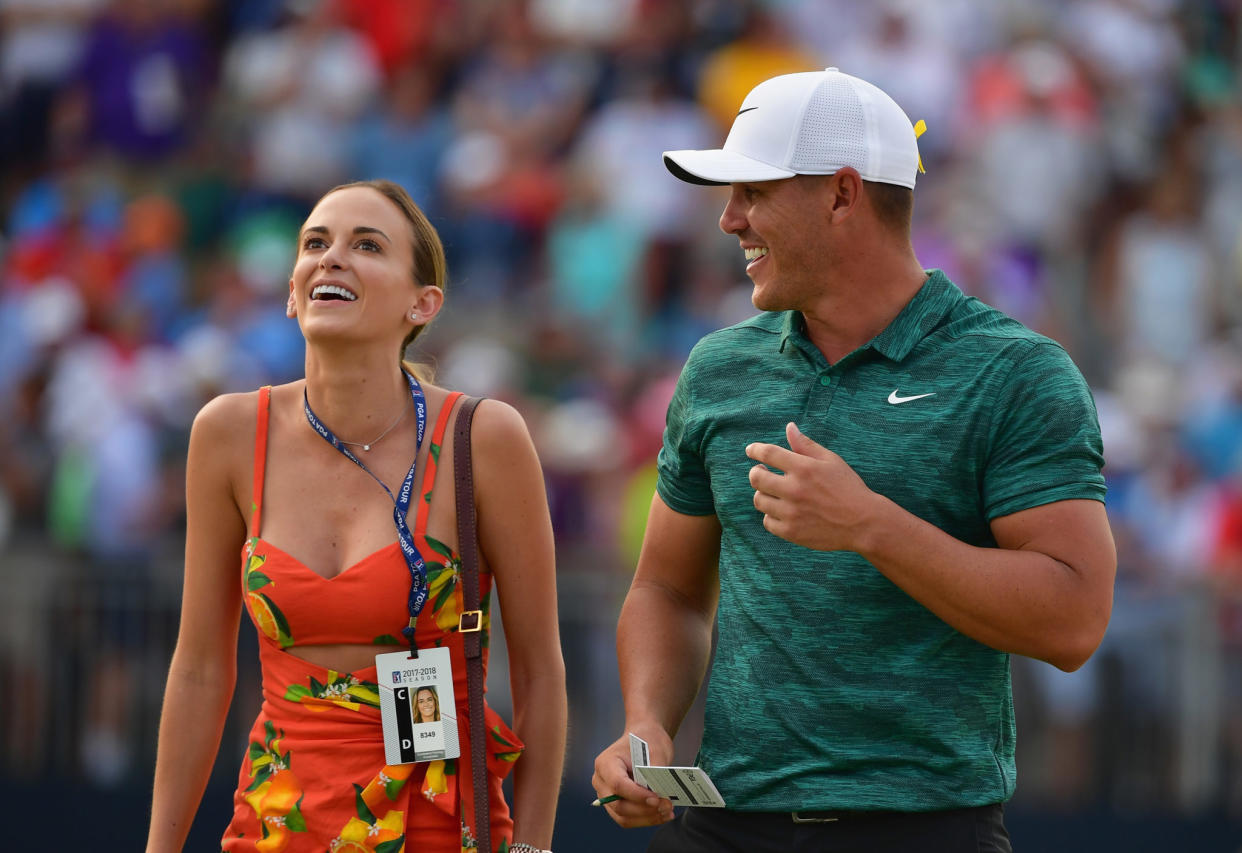 Brooks Koepka walking on the golf course with his girlfriend.