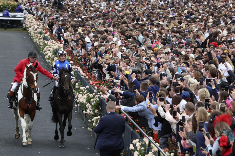 Gold Trip ridden by Mark Zahra, second left, rides past the crowd after winning the Melbourne Cup horse race in Melbourne, Australia, Tuesday, Nov. 1, 2022. (AP Photo/Asanka Brendon Ratnayake)