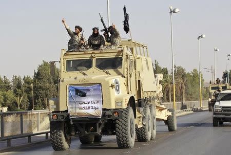 Militant Islamist fighters take part in a military parade along the streets of Syria's northern Raqqa province June 30, 2014. REUTERS/Stringer