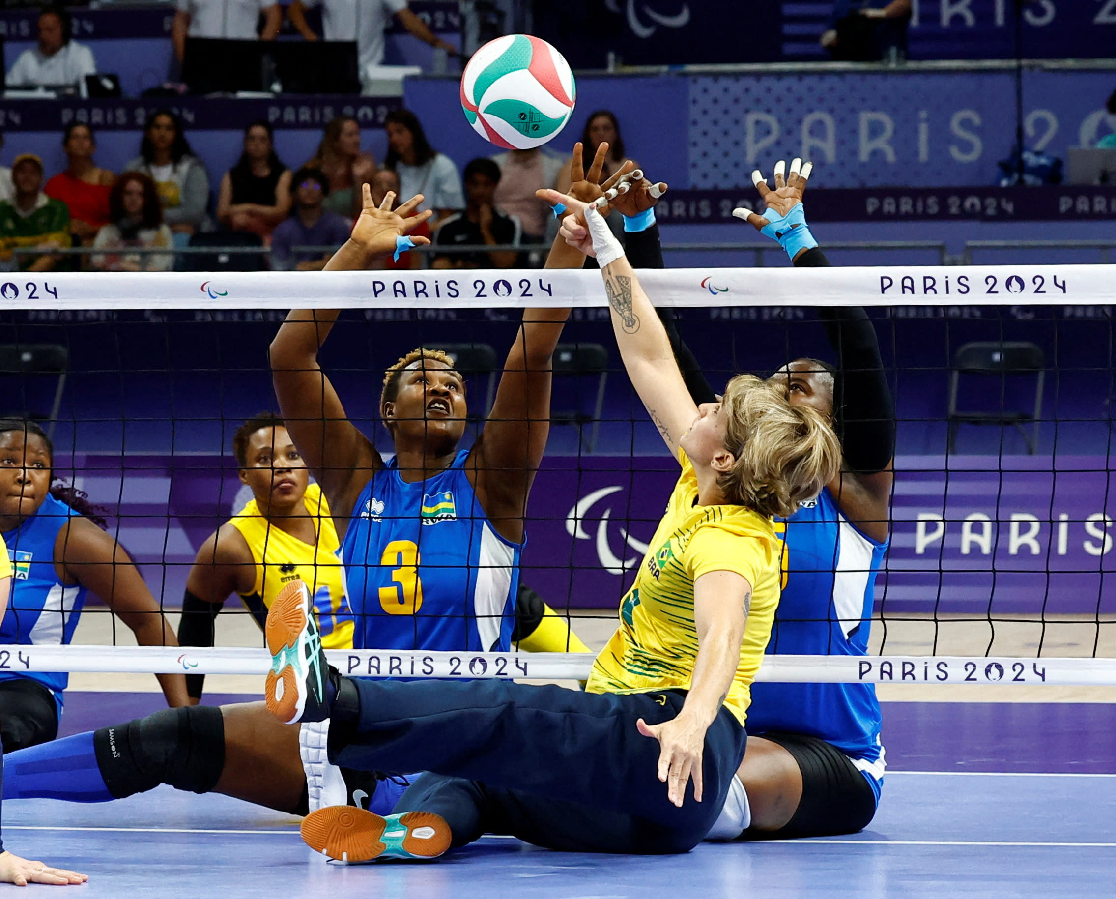 Women participating in sitting volleyball.