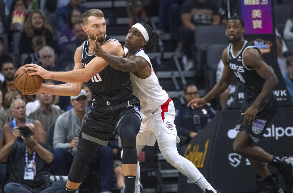 Sacramento Kings forward Domantas Sabonis (10) is guarded by Los Angeles Clippers guard Terance Mann during the first quarter of an NBA basketball game in Sacramento, Calif., Saturday, Oct. 22, 2022. (AP Photo/Randall Benton)