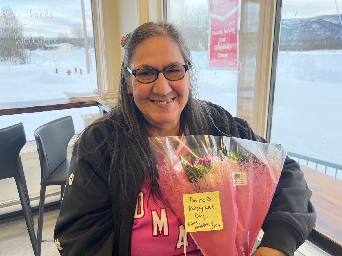 Joanne Buyck of Mayo, Yukon, with some Valentine's Day flowers. The Mayo, Yukon, resident has been following news this week about the suspected balloon that was shot down over Yukon on Saturday. It's believed to have gone down somewhere between Mayo and Dawson City. (Juanita Taylor/CBC - image credit)