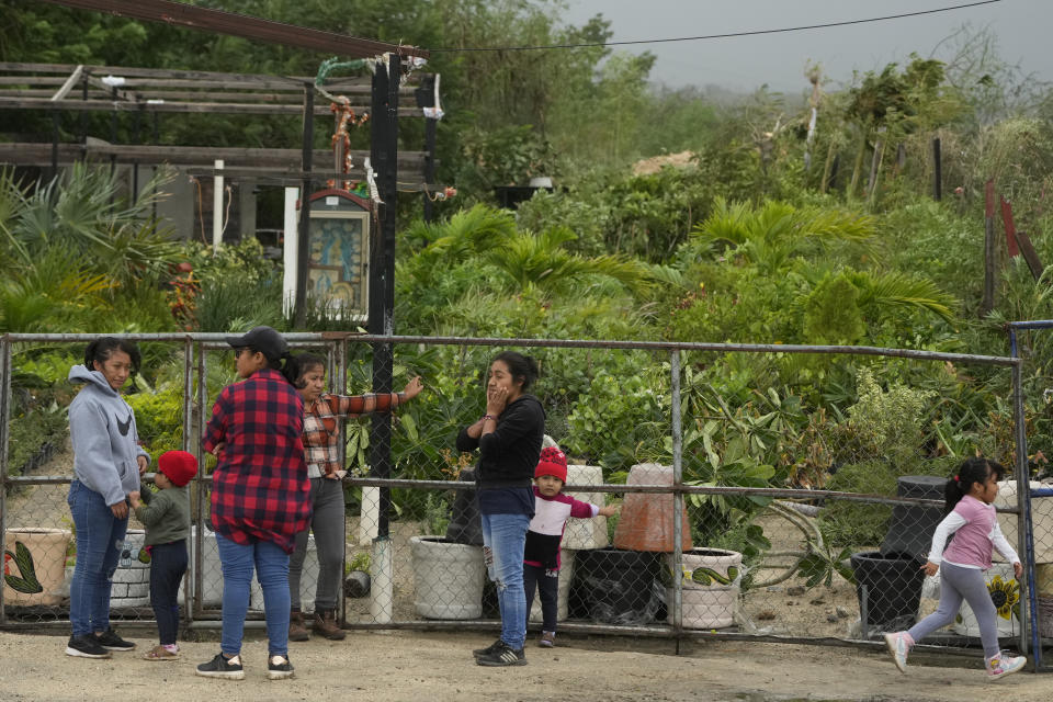 People stand outside their homes after Hurricane Norma's passage in San Jose del Cabo, Mexico, Saturday, Oct. 21, 2023. Hurricane Norma made landfall near the resorts of Los Cabos at the southern tip of Mexico's Baja California Peninsula. (AP Photo/Fernando Llano)