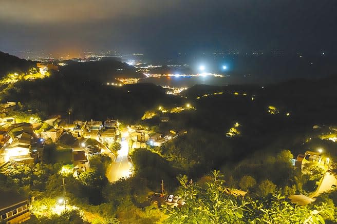 許多情侶觀賞九份絢麗的夜景，紛紛拍照打卡留念。（黃采薇攝）