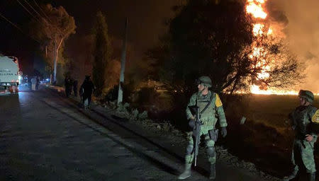 Military personnel watch as flames engulf an area after a ruptured fuel pipeline exploded, in the municipality of Tlahuelilpan, Hidalgo, Mexico, near the Tula refinery of state oil firm Petroleos Mexicanos (Pemex), January 18, 2019 in this handout photo provided by the National Defence Secretary (SEDENA). National Defence Secretary/Handout via REUTERS