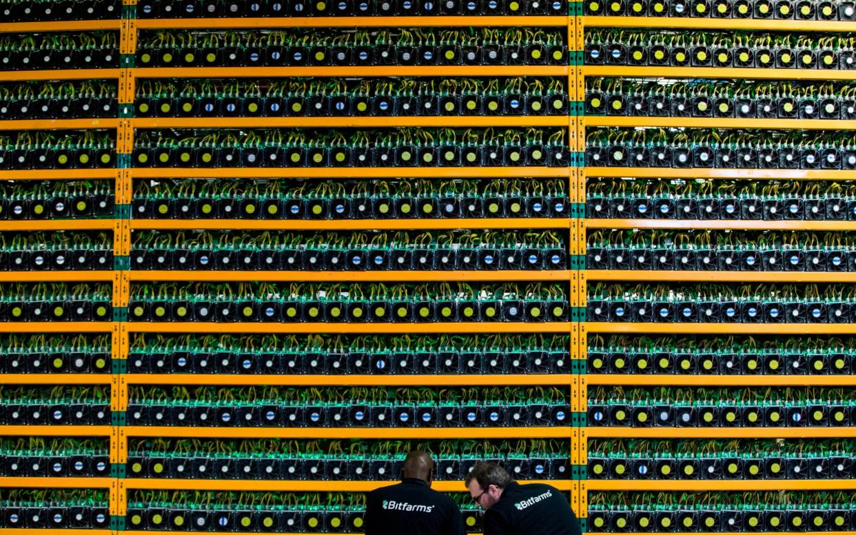 Two technicians inspect bitcon mining at Bitfarms in Saint Hyacinthe, Quebec - LARS HAGBERG/AFP/Getty Images