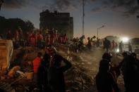 Members of rescue services search for survivors in the debris of a collapsed building in Izmir, Turkey, Monday, Nov. 2, 2020. In scenes that captured Turkey's emotional roller-coaster after a deadly earthquake, rescue workers dug two girls out alive Monday from the rubble of collapsed apartment buildings three days after the region was jolted by quake that killed scores of people. Close to a thousand people were injured. (AP Photo/Emrah Gurel)