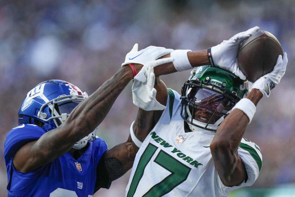 New York Jets wide receiver Garrett Wilson (17) catches a touchdown pass against New York Giants cornerback Gemon Green (34) during the first half of an NFL preseason football game, Saturday, Aug. 26, 2023, in East Rutherford, N.J. (AP Photo/Frank Franklin II)