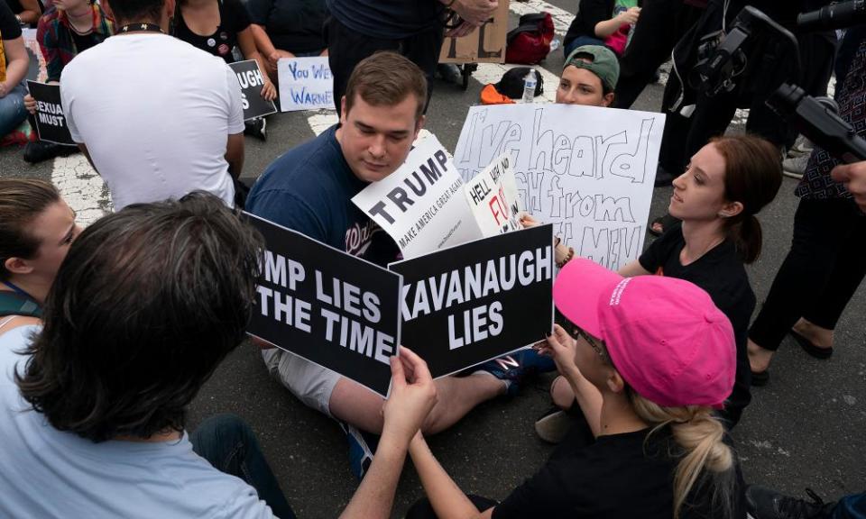 A Trump supporter sits with protesters demonstrating in opposition to the Senate confirmation of Brett Kavanaugh to the supreme court in Washington DC on Saturday.