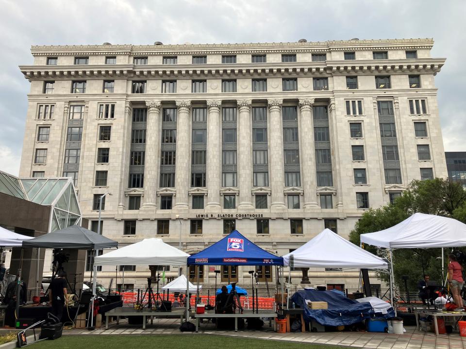 Even a thunderstorm Tuesday afternoon did not disperse the media camped outside the Lewis R. Slaton Courthouse in Atlanta where, on Monday, a grand jury indicted former president Donald J. Trump