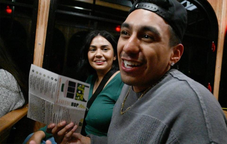 Taylor Mendoza, left, listens as Daniel Gonzales explains how the two heard about the City of Fresno’s new free FresnoHOP trolley service and were riding it from Campus Pointe to the Tower District Friday night, Nov. 10, 2023 in Fresno.