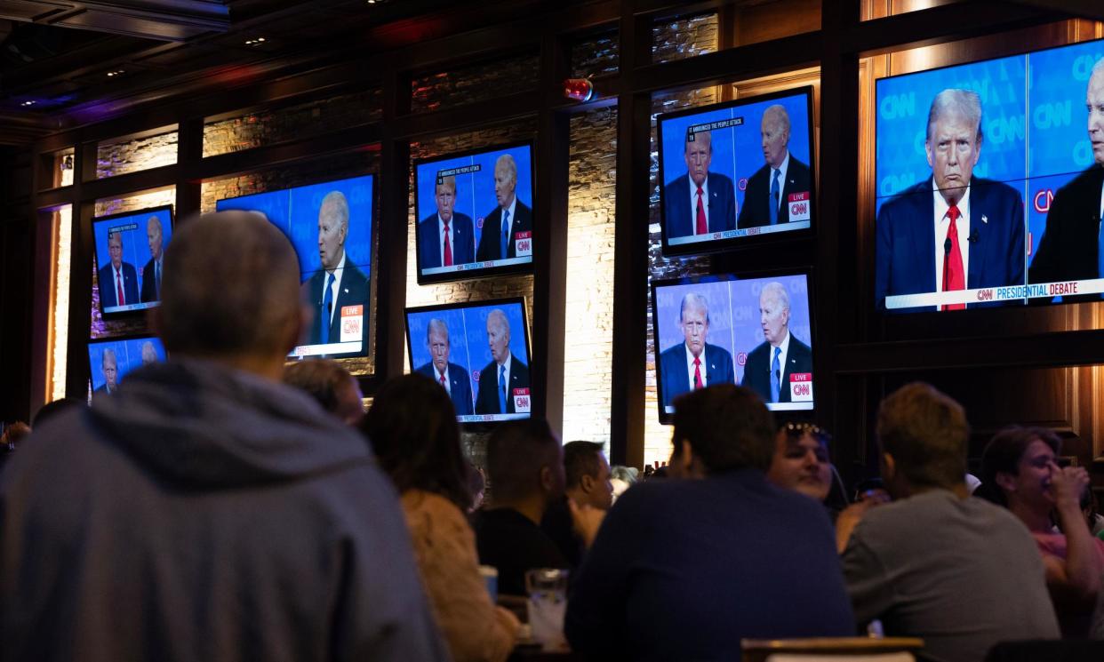 <span>People watch the presidential debate at a bar in Chicago.</span><span>Photograph: Scott Olson/Getty Images</span>