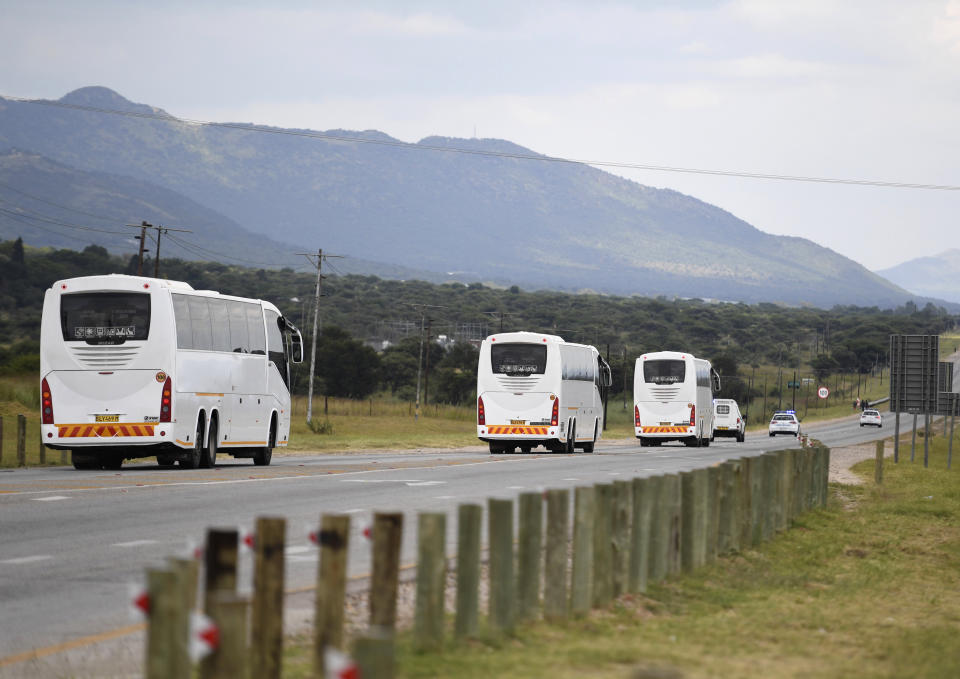 Buses carrying people who travelled from Wuhan, China, in Plokwane, South Africa, Saturday, March 14, 2020 after being repatriated where they will be kept in quarantine at a nearby resort. For most people the new coronavirus causes only mild or moderate symptoms, such as fever and cough. For some, especially older adults and people with existing health problems, it can cause more severe illness, including pneumonia. (AP Photo)