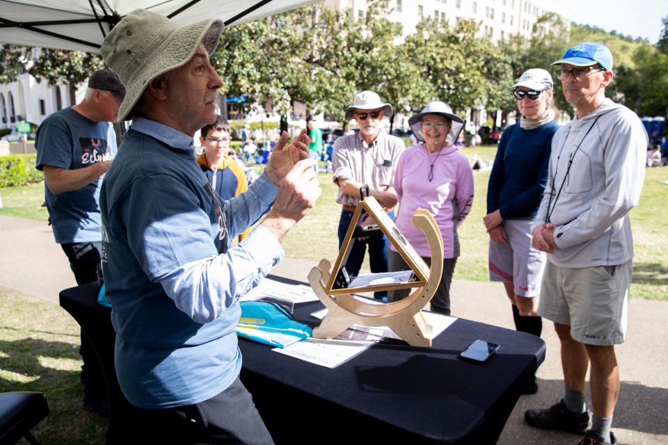 Jim Silda, with the National Oceanic and Atmospheric Administration, explains how a sun spotter works to people waiting for the total solar eclipse on Arlington Lawn at Hot Springs National Park in Hot Springs, Arkansas on Monday, April 8, 2024.