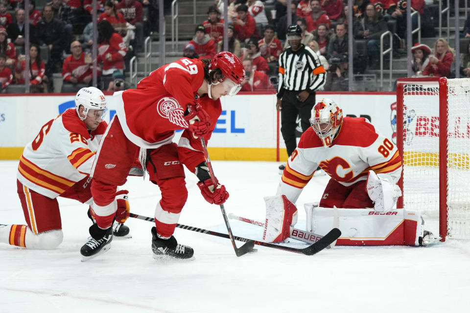 Calgary Flames goaltender Dan Vladar (80) stops a Detroit Red Wings left wing Tyler Bertuzzi (59) shot as Calgary Flames defenseman Michael Stone (26) defends in the second period of an NHL hockey game Thursday, Feb. 9, 2023, in Detroit. (AP Photo/Paul Sancya)