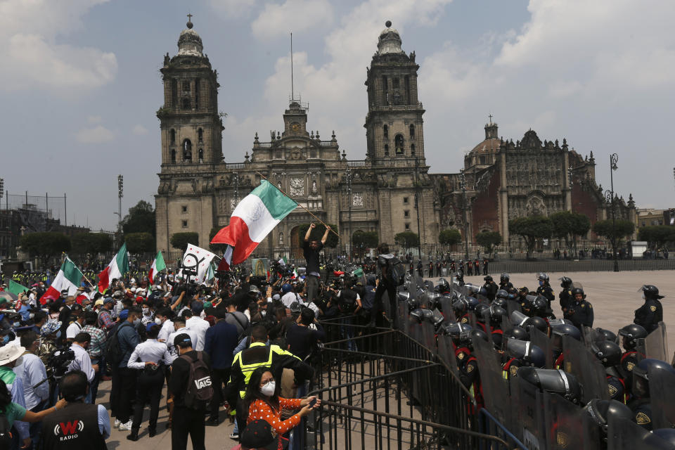 Police in riot gear block demonstrators who are demanding the resignation of Mexican President Andrés Manuel López Obrador, commonly known by his initials AMLO, from entering Mexico City's main square the Zocalo, Wednesday, Sept. 23, 2020. (AP Photo/Marco Ugarte)