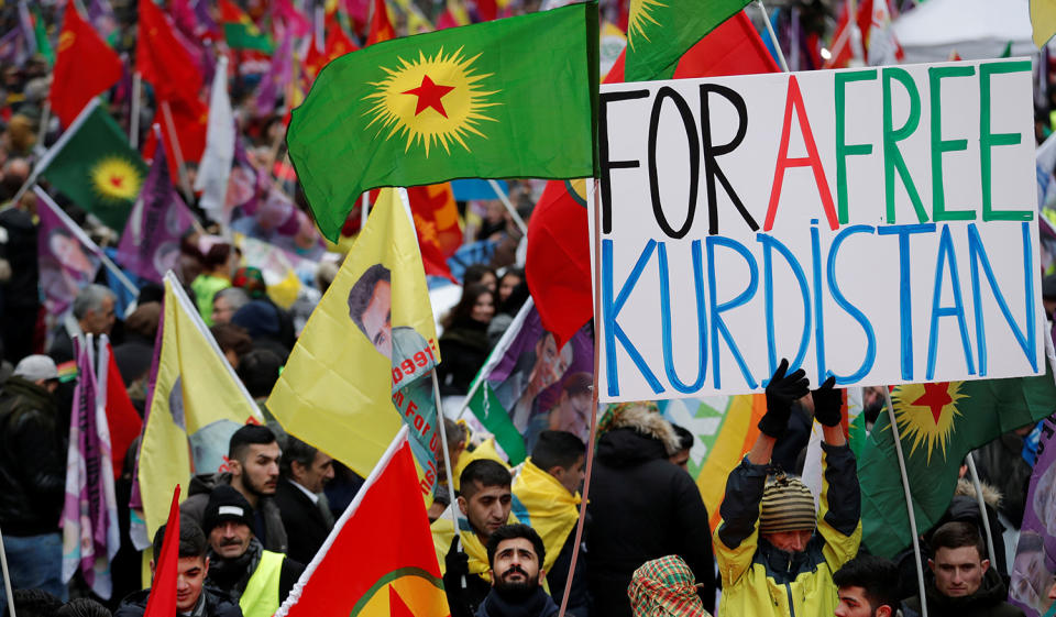 The Kurdish community hold banners and flags in Paris