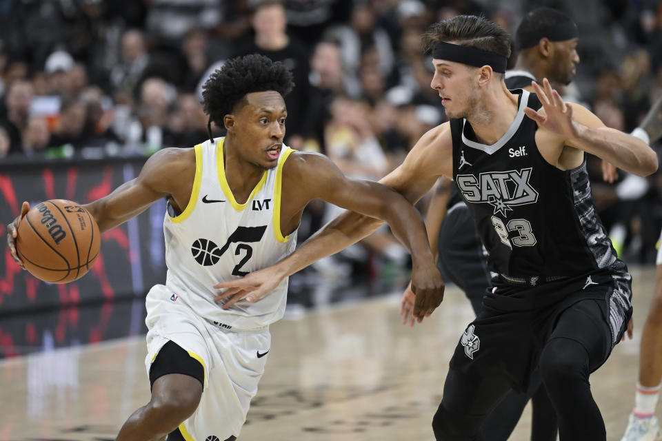 Utah Jazz's Collin Sexton (2) drives against San Antonio Spurs' Zach Collins during the first half of an NBA basketball game Tuesday, Dec. 26, 2023, in San Antonio. (AP Photo/Darren Abate)