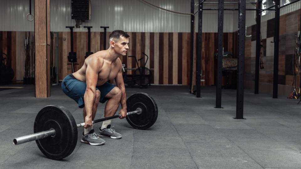 Man performing a barbell deadlift during workout