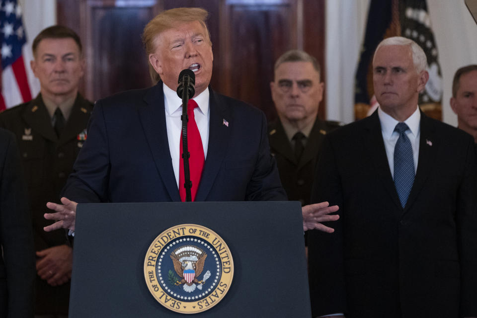 President Donald Trump addresses the nation from the White House on the ballistic missile strike that Iran launched against Iraqi air bases housing U.S. troops, Wednesday, Jan. 8, 2020, in Washington, as Chairman of the Joint Chiefs of Staff Gen. Mark Milley, Vice President Mike Pence, and others look on. (AP Photo/ Evan Vucci)