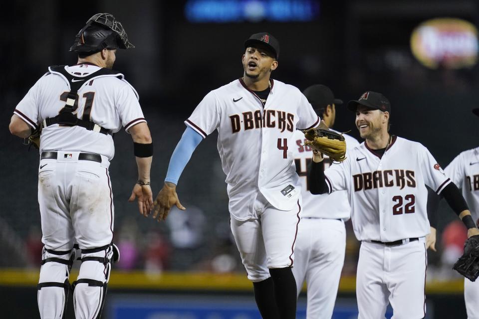 Arizona Diamondbacks' Stephen Vogt, left, celebrates a win against the Milwaukee Brewers with Diamondbacks' Ketel Marte (4) and Josh Reddick (22) after the final out of the ninth inning of a baseball game Monday, June 21, 2021, in Phoenix. The Diamondbacks defeated the Brewers 5-1. (AP Photo/Ross D. Franklin)