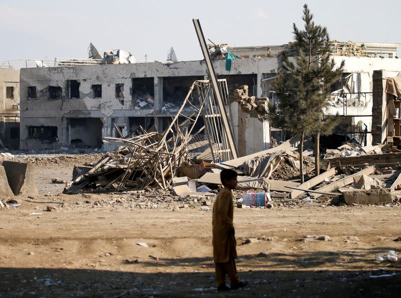 An Afghan boy stands at the site of an attack in a U.S. military air base in Bagram