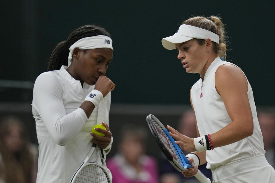 Coco Gauff of the U.S., left, and compatriot Caty McNally speak during the women's doubles third round match against Russia's Veronika Kudermetova and Elena Vesnina on day eight of the Wimbledon Tennis Championships in London, Tuesday, July 6, 2021. (AP Photo/Kirsty Wigglesworth)