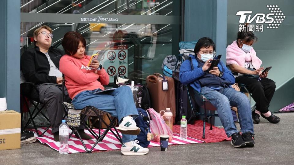 台北小巨蛋外的民眾用各種方式打發排隊時間。（圖／張哲鳴攝）