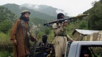 FILE - In this Aug. 5, 2012, file photo, Pakistani Taliban patrol in their stronghold of Shawal in Pakistani tribal region of South Waziristan. Militant attacks are on the rise in Pakistan amid a growing religiosity that has brought greater intolerance, prompting one expert to voice concern the country could be overwhelmed by religious extremism. (AP Photo/Ishtiaq Mahsud, File)