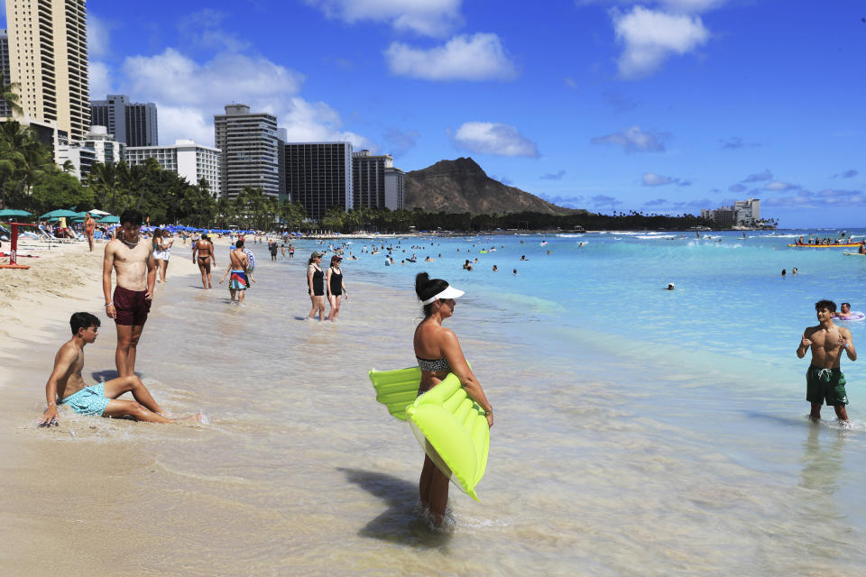 Beach goers take to the waves on Waikiki Beach, Thursday, June, 23, 2022 in Honolulu. In a major expansion of gun rights after a series of mass shootings, the Supreme Court said Thursday that Americans have a right to carry firearms in public for self-defense.
