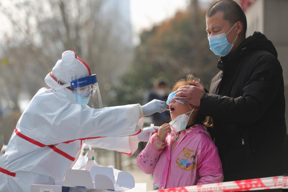 A medical worker takes swab for SARS-COV-2 testing on a resident on the sidewalk in Wuhan in central China's Hubei province Thursday, March 05, 2020. (Photo: Barcroft Media via Getty Images)