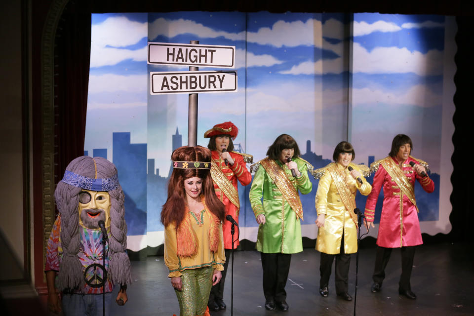 In this Wednesday, Dec. 4, 2019 photo, characters portraying Haight-Ashbury hippies and the Beatles perform during the musical "Beach Blanket Babylon" in San Francisco. The campy small San Francisco show that's been a must-see for tourists and locals alike for more than 45 years, making it the nation's longest continuously running musical revue, is closing its curtain. Its final performance is set for New Year’s Eve. (AP Photo/Eric Risberg)