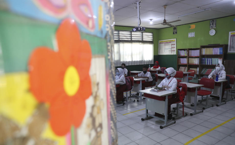 Indonesian students sit spaced apart to practice social distancing as a precaution against the new coronavirus outbreak during a class in Bekasi on the outskirts of Jakarta, Indonesia, Monday, Aug. 3, 2020. (AP Photo/Achmad Ibrahim)