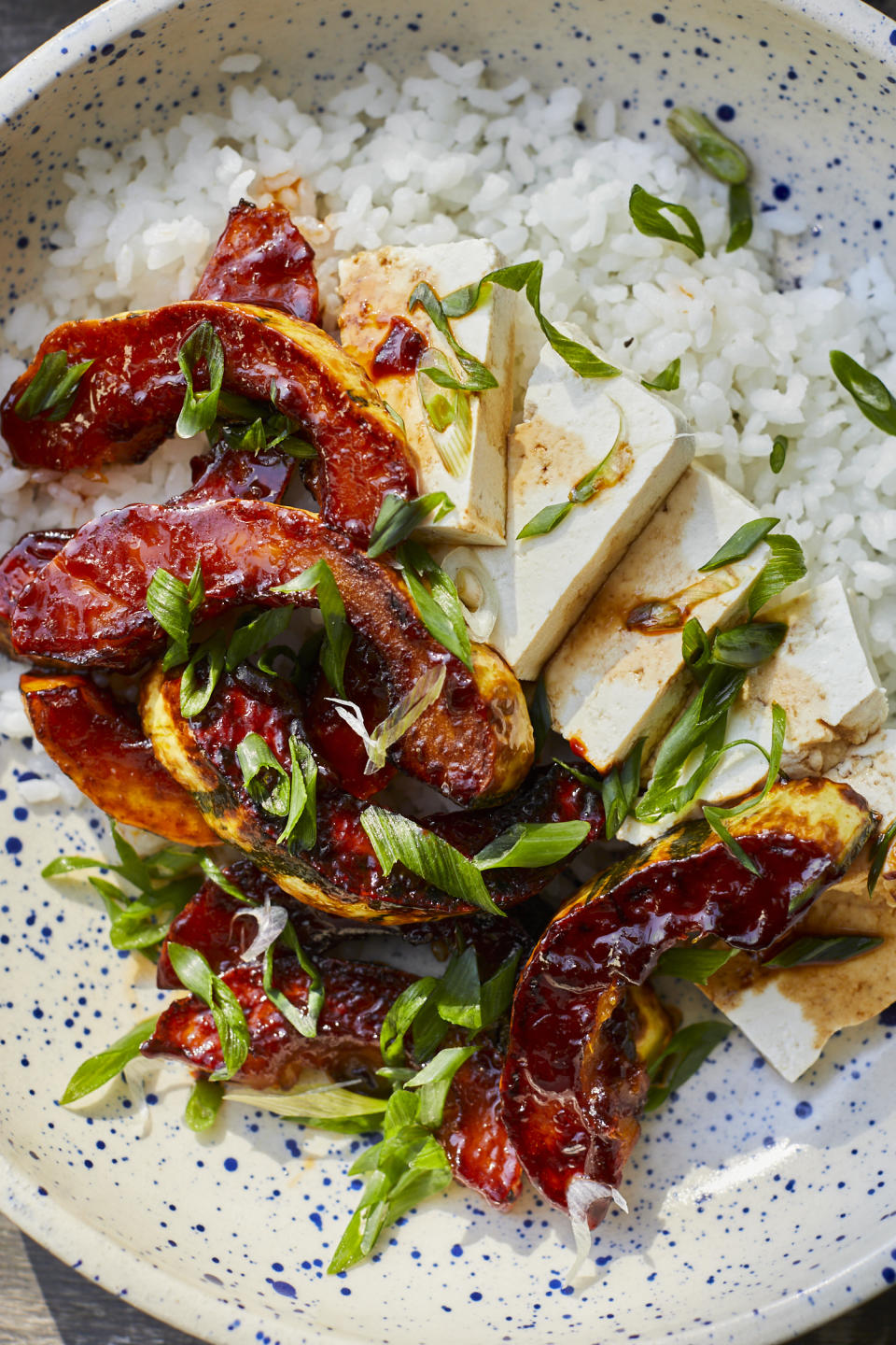 gochujang delicata squash served alongside rice and tofu and topped with scallions