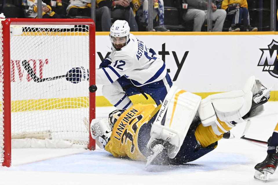 Nashville Predators goaltender Kevin Lankinen (32) blocks a shot by Toronto Maple Leafs center Zach Aston-Reese (12) during the first period of an NHL hockey game Sunday, March 26, 2023, in Nashville, Tenn. (AP Photo/Mark Zaleski)