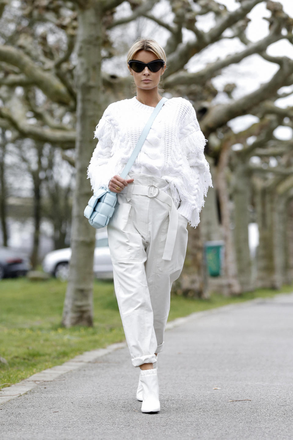 DUSSELDORF, GERMANY - MARCH 20: Influencer Gitta Banko, wearing a white fringed sweater and paperbag pants by Iro, white booties by Celine, topaz padded casette bag by Bottega Veneta and sunglasses by Mykita x Maison Margiela during a street style shooting on March 20, 2020 in Dusseldorf, Germany. (Photo by Isa Foltin/Getty Images)