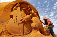 <p>Sand carver Sergey Aseer from Russia works on a sculpture during the Sand Sculpture Festival “Disney Sand Magic” in Ostend, Belgium June 22, 2017. (Yves Herman/Reuters) </p>