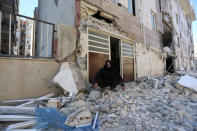 A man sits outside a damaged belonging following an earthquake in Sarpol-e Zahab county in Kermanshah, Iran. REUTERS/Tasnim News Agency