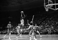 FILE - New York Nets Julius Erving (32), known as "Dr. J", leaps for the basket on way to 35 points against the Kentucky Colonels at the Nassau Coliseum in Uniondale, N.Y., Jan. 24, 1976. Nets Bill Melchionni (25), Colonels Kevin Joyce (43) and John Neumann watch the performance. The ABA developed some true stars of the game, including Calvin, Julius Erving, Artis Gilmore and George Gervin, but it's largely remembered for paltry crowds, shaky finances and a red, white and blue ball. (AP Photo/Harry Harris, File)