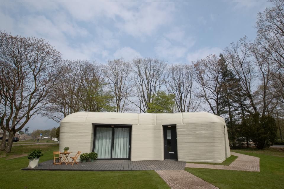 Exterior view showing the printer layers of the 3D-printed 1,011-square feet, two-bedroom bungalow resembling a boulder with windows in Eindhoven, Netherlands, April 2021.