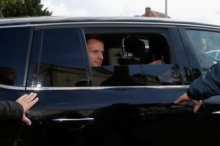 Emmanuel Macron (C), head of the political movement En Marche !, or Onwards !, and candidate for the 2017 French presidential election, sits in his car as he leaves after a meeting with Whirlpool employees in front of the company plant in Amiens, France, April 26, 2017. REUTERS/Pascal Rossignol