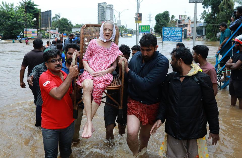 <p>Indian volunteers and rescue personal evacuate local residents in a residential area in Ernakulam district, in the Indian state of Kerala, on August 17, 2018. Troop reinforcements stepped up desperate rescue attempts in India’s flood-stricken Kerala state on August 17 after more than 100 bodies were found in a day and a half, taking the crisis death toll to at least 164. (Photo by AFP/Getty Images) </p>