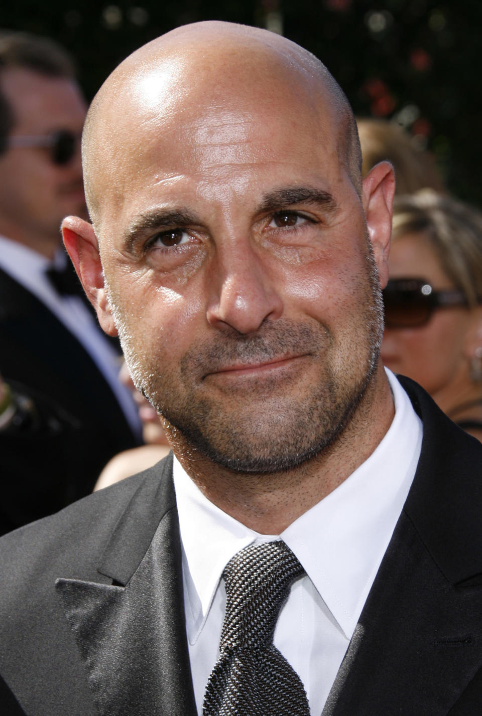 Man in a formal suit with a tie on a sunny day, likely at an event