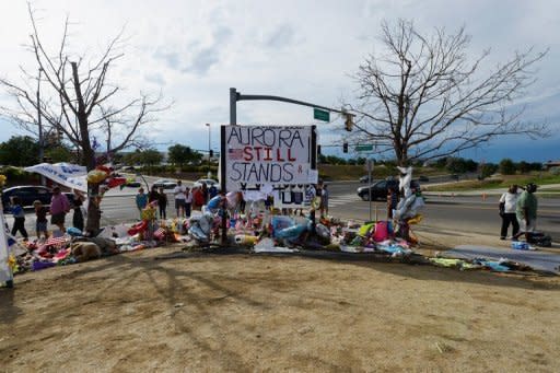 People continue to visit the roadside memorial set up for victims of the Colorado theater shooting massacre across the street from Century 16 movie theater on July 29 in Aurora, Colorado