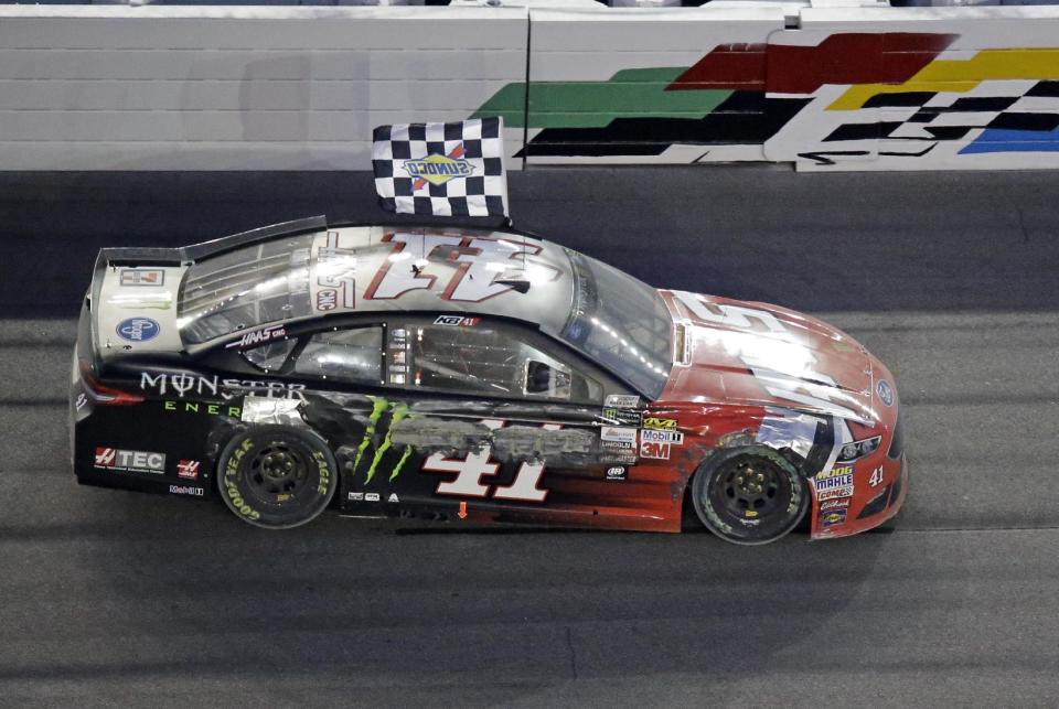 Kurt Busch drives in front of the ran stand waving the checkerd flag after winning the Daytona 500 auto race at Daytona International Speedway, Sunday, Feb. 26, 2017, in Daytona Beach, Fla. (AP Photo/John Raoux)