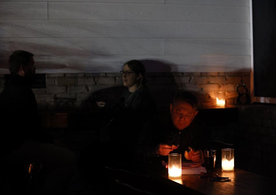 Patrons dine by candelight at Red's Corner during the Moore County power outage, Monday, Dec. 5, 2022, in Southern Pines, N.C. Tens of thousands of people are bracing for days without electricity in Moore County where authorities say two power substations were shot up by one or more people with apparent criminal intent. (Kaitlin McKeown/The News & Observer via AP)