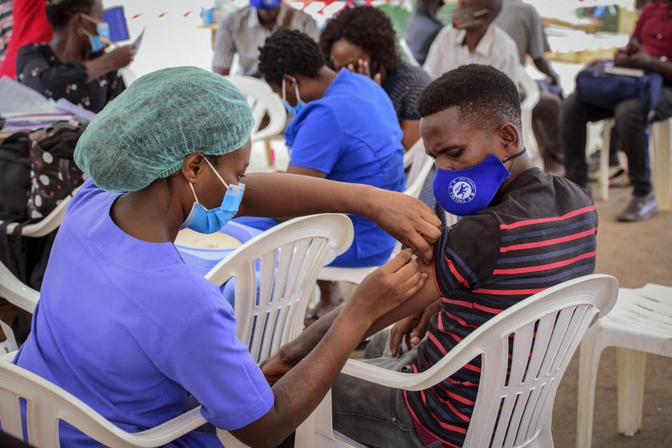 A nurse administers a coronavirus vaccination to a patient at a streetside vaccination tent in downtown Kampala, Uganda Tuesday, Sept. 7, 2021. Uganda is accelerating its vaccination drive in order to administer 128,000 doses that recently arrived and expire at the end of September. (AP Photo/Nicholas Bamulanzeki)