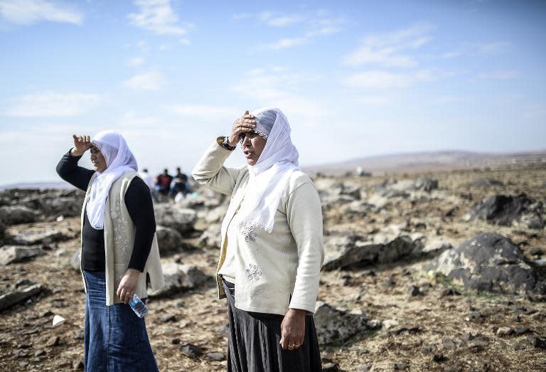 Kurdish women look at the Syrian town of Kobane, also known as Ain al-Arab, on October 26, 2014 from the Turkish border