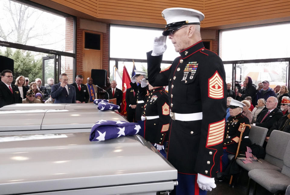 In this Jan. 17, 2019 photo, a retired U.S. Marine Master Gunnery Sergeant salutes three Memphis veterans, Wesley Russell, 76, Arnold Klechka, 71, Charles Fox, 60, who died this past fall and whose remains were unclaimed, in Memphis, Tenn. Funeral homes, medical examiners, state and federal veterans’ affairs departments, and local veterans’ groups have combined forces to honor members of the military whose bodies were not claimed by any relatives. (AP Photo/Karen Pulfer Focht)